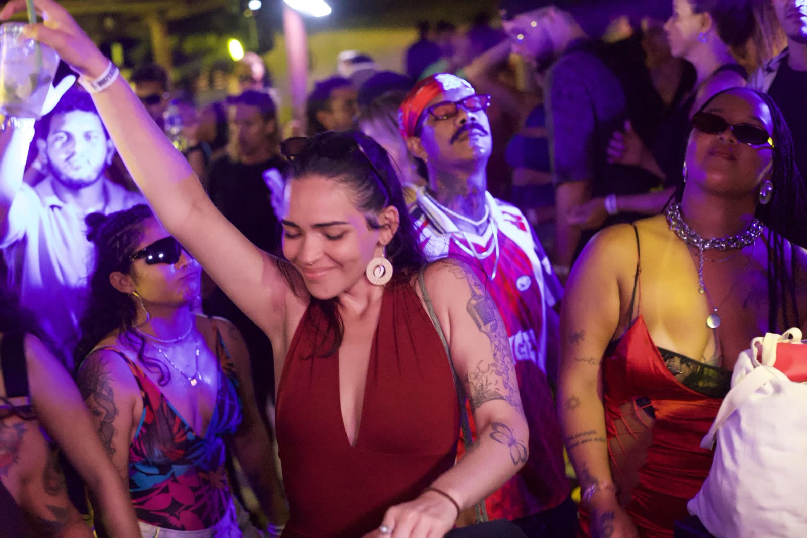 Público dançando sob luz violeta